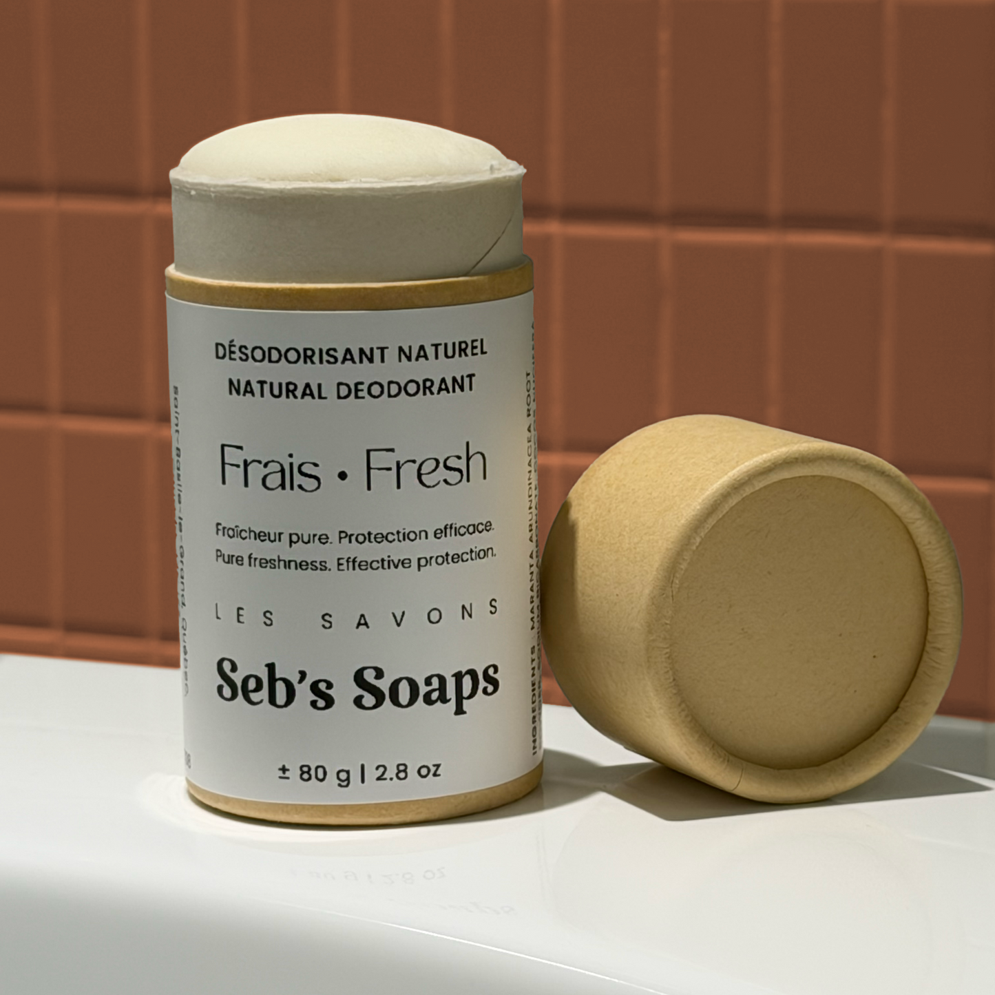 Seb's Soaps Fresh Natural Deodorant cardboard tube with lid on a bathtub with a tiled wall in background